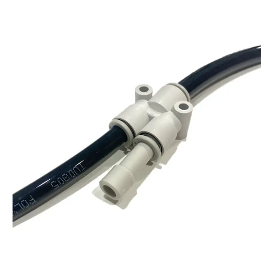 A close-up of the PMI SmokeNINJA Special Effect Tubing Kit shows a black tube connected to a white plastic fitting with two round openings and two screw holes, used for fluid transfer in Smoke Ninja or Smoke Genie systems.
