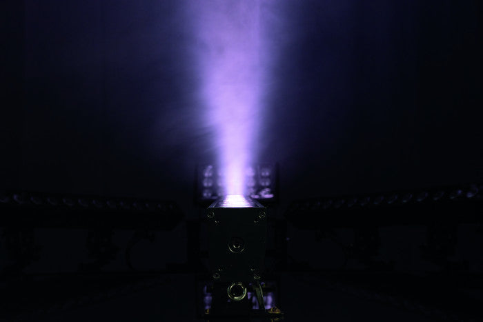 A vibrant purple beam or plume of plasma emerges from a rectangular device in a dark room, evoking the luminous effects produced by professional stage lighting like the Showtec Cameleon Bar 15 Q6 Tour RGBWA-UV LED Bar from Showtec.