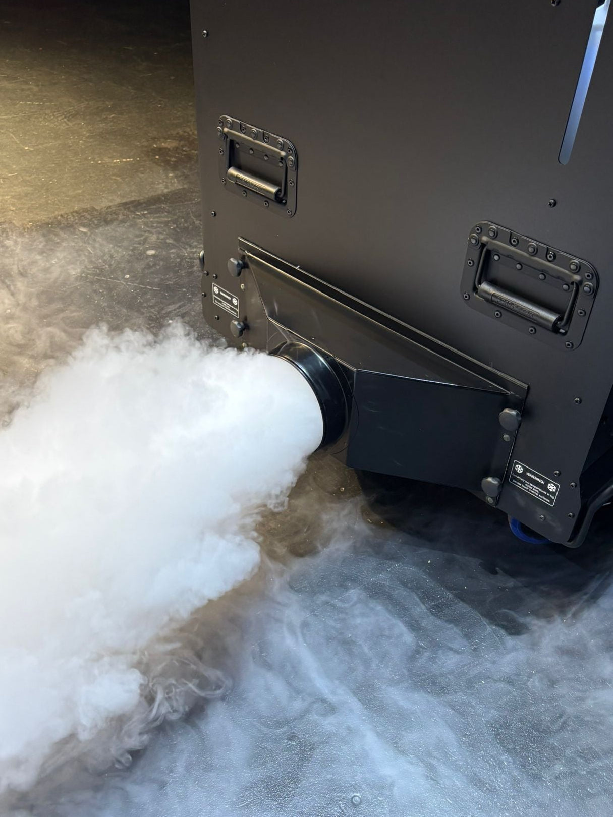 Black Glaciator Dynamic emitting a large amount of white smoke or vapor on a concrete floor from the Single Output ducting adaptor.