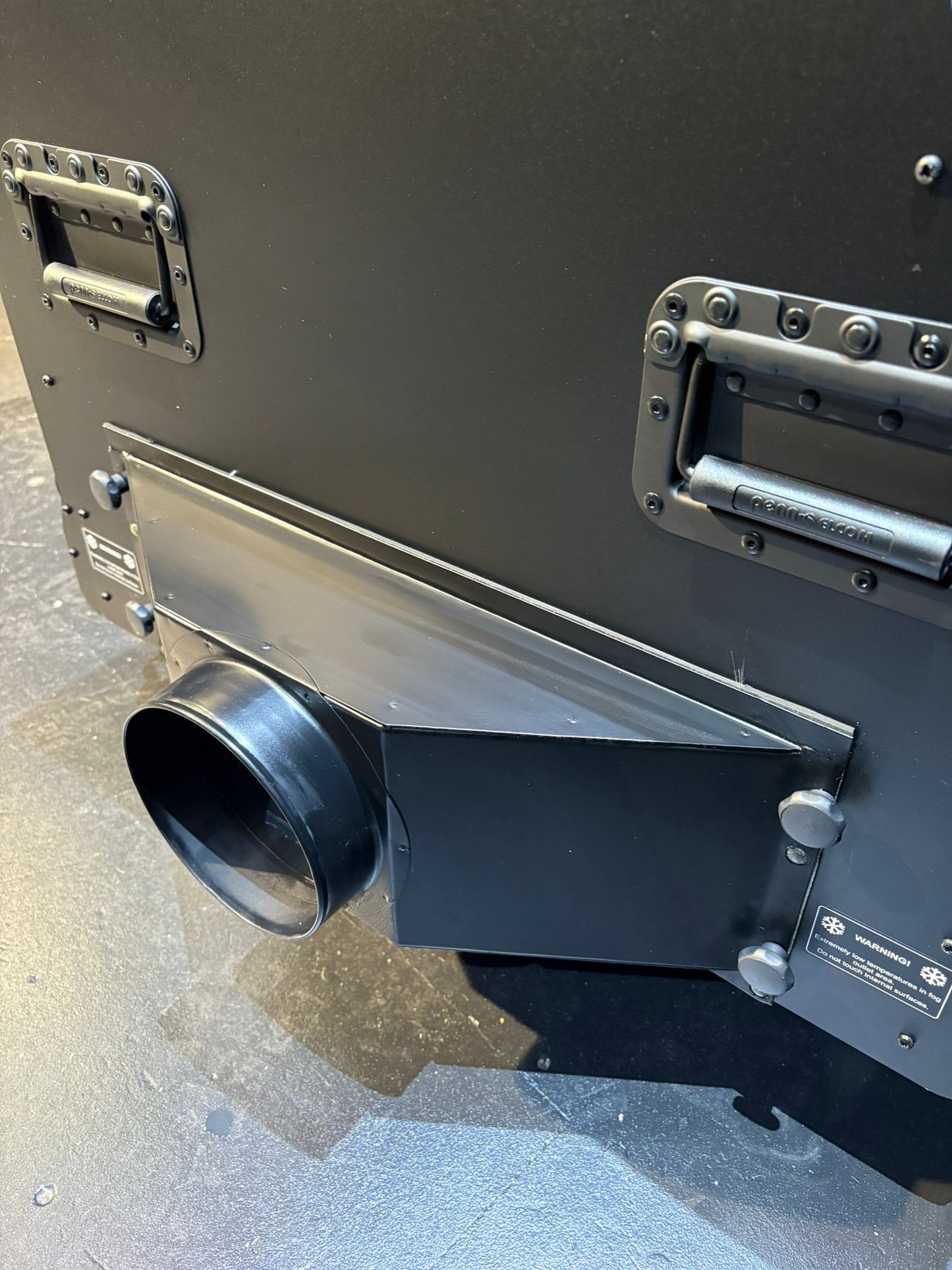 Metallic cylindrical object with a black exhaust or vent on a gray surface