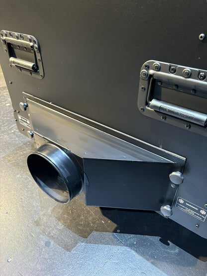 Metallic cylindrical object with a black exhaust or vent on a gray surface