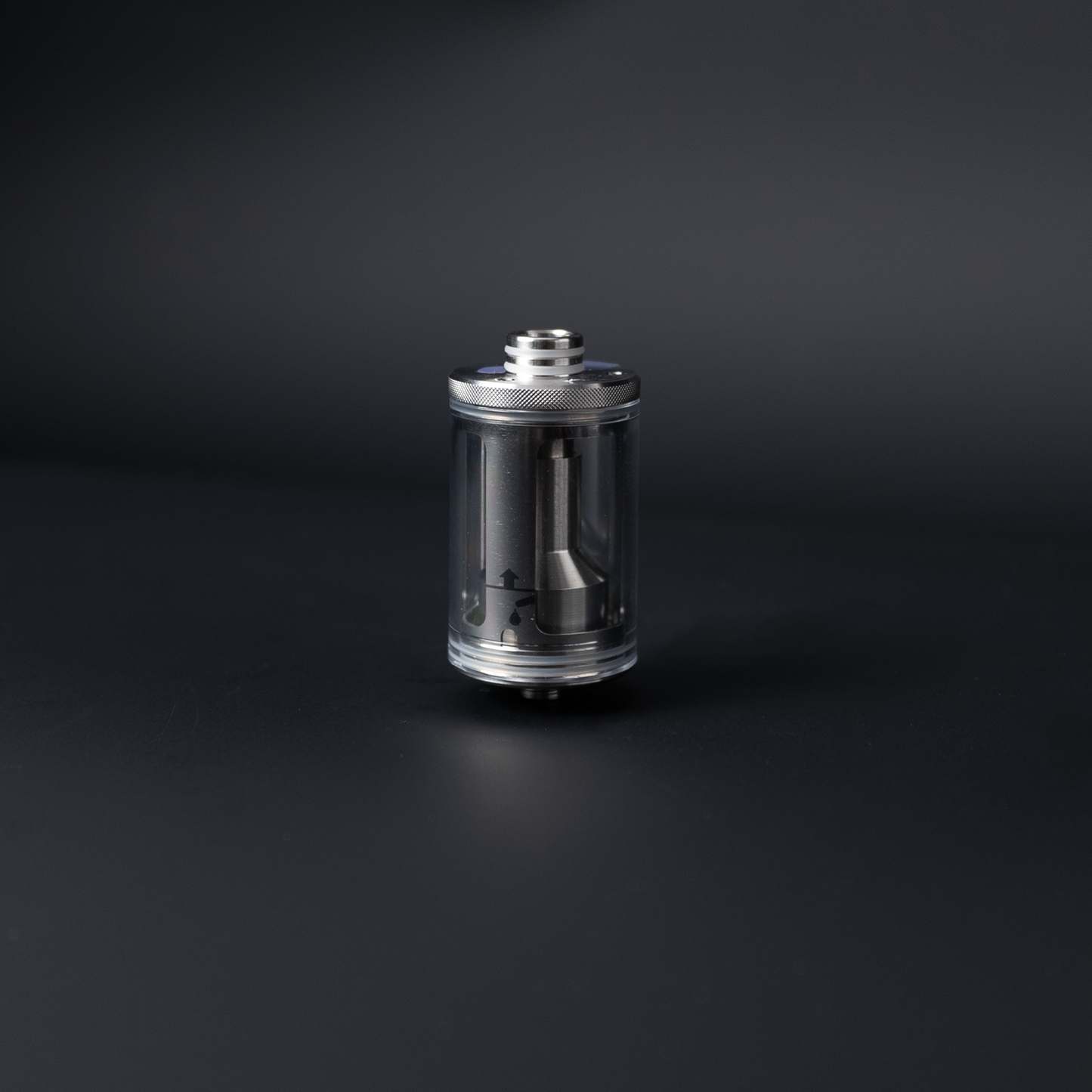 The PMI SmokeNINJA/GENIE Rep Shockproof Chamber (PMI_AC_CHAMB) stands upright on a dark surface, its cylindrical metal and glass body and threaded top highlighting the durable stainless steel chamber inside.