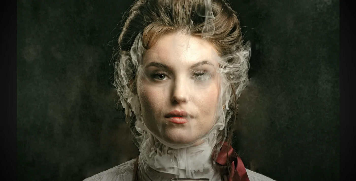 A woman with vintage hair and clothing gazes ahead, her face partially veiled by cinematic haze from the PMI SmokeNINJA Pro Hazer Kit, creating a dramatic effect ideal for photography or film needing a mysterious atmosphere.