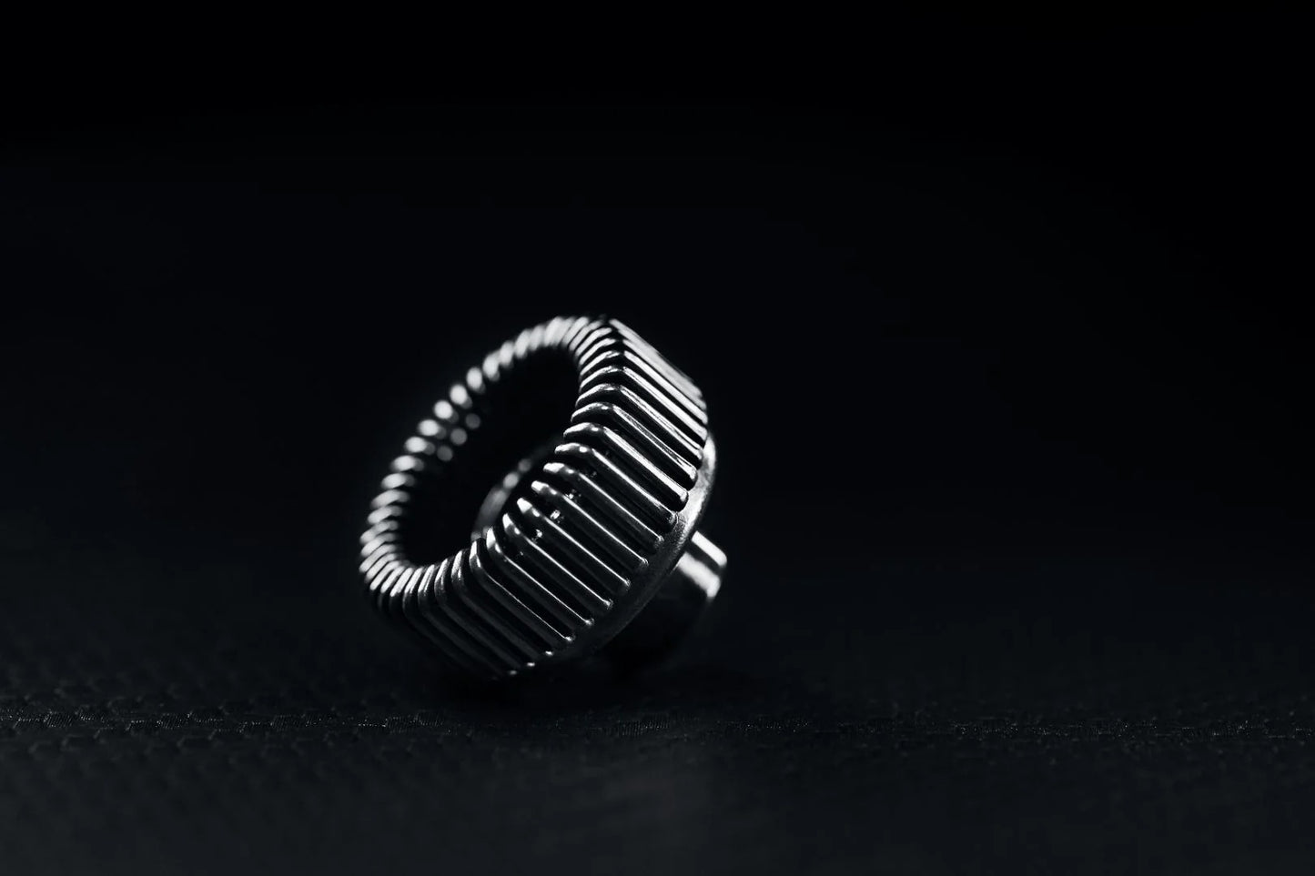 The PMI SmokeNINJA Bubble Kit 100ml is shown on a dark, textured surface, its shiny finish illuminated—like a bubble nozzle casting reflections against a black background.