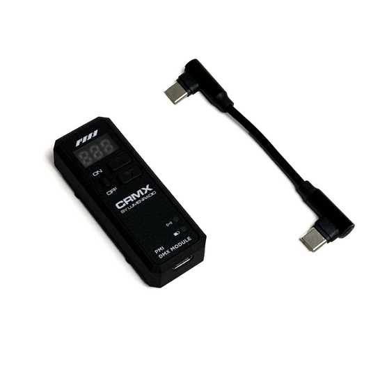 A rectangular black device labeled "SmokeNINJA PMI Wireless DMX Receiver" by PMI, with buttons and a display, uses Lumenradio CRMX wireless DMX. Shown on a white background next to a short black USB-C to USB-C adapter cable.