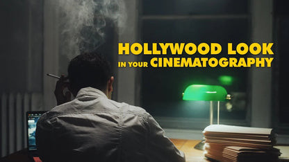 A person sits at a desk in a dim room, cigarette in hand. Green desk lamp and paper stacks add to the cinematic vibe, enhanced by PMI SmokeNINJA Pro Hazer Kit. Bold yellow text: HOLLYWOOD LOOK IN YOUR CINEMATOGRAPHY.