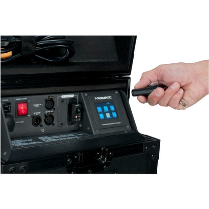 A hand holds a remote, aimed at an open black Elation Magmatic MagRF (ELA-1412000013) case featuring control switches, ports, a red power switch, and a blue digital display—perfect for Magmatic Atmospheric products.